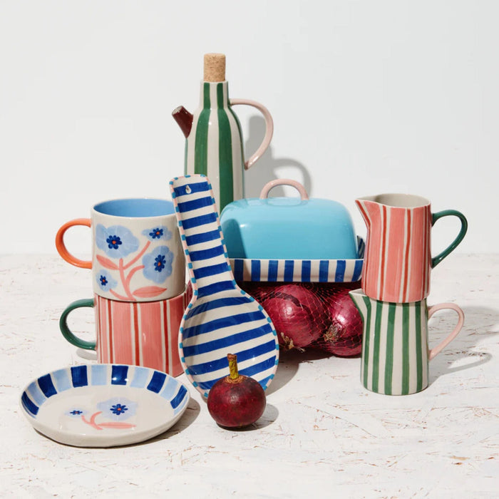 Colorful ceramic kitchenware items on a light wooden surface