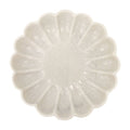 White marble plate with a textured, flower-like design on a white background